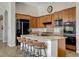 Kitchen island with stone countertop and bar stool seating overlooking stainless steel appliances at 3 Chenal Pass, Henderson, NV 89052