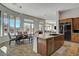 Bright kitchen featuring a granite island, wood cabinets, stainless appliances, and a view to the outdoor dining area at 3 Chenal Pass, Henderson, NV 89052