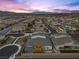 Stunning aerial view of a modern home with a spacious backyard, desert landscape, and city skyline in the distance at 3025 Merlesco Ave, Henderson, NV 89044