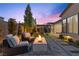 Inviting twilight backyard, featuring a gas fireplace, seating, playground and kitchen at 3025 Merlesco Ave, Henderson, NV 89044