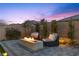 Elegant twilight backyard with a modern gas fireplace and comfortable seating at 3025 Merlesco Ave, Henderson, NV 89044