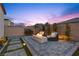 Cozy backyard design with a modern gas fireplace, pavers, and elegant twilight at 3025 Merlesco Ave, Henderson, NV 89044