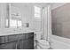 Bright bathroom featuring a large vanity, modern fixtures, a toilet, and a shower with decorative curtain at 3025 Merlesco Ave, Henderson, NV 89044