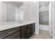 A bathroom featuring a single sink vanity, large mirror, and a shower/tub combo in the background at 3025 Merlesco Ave, Henderson, NV 89044