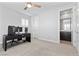 Neutral-toned bedroom featuring a work station with three windows and a ceiling fan at 3025 Merlesco Ave, Henderson, NV 89044