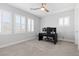 Neutral bedroom featuring three window with white shutters, a ceiling fan, and a work station at 3025 Merlesco Ave, Henderson, NV 89044