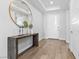 Bright entryway with a modern wood console table, a gold mirror, and wood-look tile floors at 3025 Merlesco Ave, Henderson, NV 89044