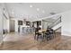 Open-concept layout with a kitchen, dining area, and staircase featuring wood-look tile floors at 3025 Merlesco Ave, Henderson, NV 89044