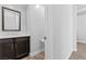 The powder room has a modern vanity with decorative mirror and wood-look flooring at 3025 Merlesco Ave, Henderson, NV 89044