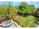 Lush backyard featuring a lawn, jacuzzi, and mature landscaping at 306 Treehouse Ct, Henderson, NV 89012