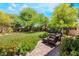 Backyard featuring a well-manicured lawn, lush landscaping and a brick patio at 306 Treehouse Ct, Henderson, NV 89012