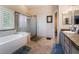 Bright bathroom featuring a large tub, enclosed glass shower, and gray vanity at 306 Treehouse Ct, Henderson, NV 89012