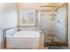 Clean bathroom featuring a large tub and enclosed glass shower at 306 Treehouse Ct, Henderson, NV 89012