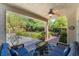 Relaxing covered patio with comfortable seating, ceiling fan, and open view to the landscaped backyard at 306 Treehouse Ct, Henderson, NV 89012