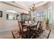 Elegant dining room with chandelier, shutters, dark wood furniture, and view to kitchen at 306 Treehouse Ct, Henderson, NV 89012