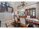 Open dining area with elegant chandelier, wood table, and a view of the staircase and kitchen at 306 Treehouse Ct, Henderson, NV 89012