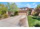 Inviting two-story home showcasing a concrete driveway, lush lawn, and charming desert landscaping at 306 Treehouse Ct, Henderson, NV 89012