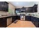 Well-appointed kitchen featuring dark cabinetry, stainless steel appliances, and wood-look flooring at 306 Treehouse Ct, Henderson, NV 89012