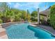 Inviting backyard pool area featuring a connected spa, waterfall features, and lush landscaping at 306 Treehouse Ct, Henderson, NV 89012