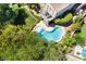 Aerial view of a kidney shaped pool featuring a diving board, spa, and stone patio at 306 Treehouse Ct, Henderson, NV 89012