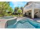 Beautiful pool and spa featuring waterfall and well-manicured landscaping, creating a backyard oasis at 306 Treehouse Ct, Henderson, NV 89012