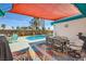 Inviting backyard patio features a dining set, bar, and turquoise swimming pool under a shaded canopy at 3212 Sundown Dr, Las Vegas, NV 89169