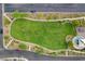 Drone's view of the lush green lawn and playground; surrounded by landscaped walkways in a welcoming neighborhood at 387 Layla Bay St, Henderson, NV 89014