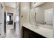 Bathroom vanity with white countertop, dark cabinets, mirror, and views to bedroom at 387 Layla Bay St, Henderson, NV 89014