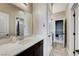 Bathroom vanity with white countertop, dark cabinets, mirror and views to additional rooms at 387 Layla Bay St, Henderson, NV 89014