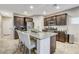 Modern kitchen featuring dark wood cabinetry, stainless steel appliances, and a granite island with bar stools at 387 Layla Bay St, Henderson, NV 89014