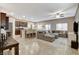 Open-concept living space with tile flooring, a large sectional sofa, and an adjacent kitchen and dining area at 387 Layla Bay St, Henderson, NV 89014