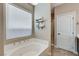 Bright main bathroom featuring a tub, a large window, neutral decor, and a separate shower at 387 Layla Bay St, Henderson, NV 89014