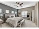 Well-lit main bedroom with neutral gray tones, a ceiling fan, and an oversized mirror at 387 Layla Bay St, Henderson, NV 89014