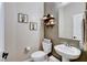 Charming powder room featuring a pedestal sink, decorative shelves, and stylish cactus-themed wall art at 387 Layla Bay St, Henderson, NV 89014