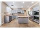 Well-lit kitchen with stainless steel appliances, a center island, gray cabinets, and tile backsplash at 4133 Perfect Lure St, Las Vegas, NV 89129