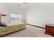 Bright bedroom with neutral carpet, ceiling fan, and a sliding glass door for natural light at 4200 Topsider St, Las Vegas, NV 89129