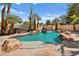 Beautiful pool with a rock waterfall, spa, and lush landscaping, perfect for summer fun and relaxation at 4200 Topsider St, Las Vegas, NV 89129