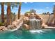 Luxurious backyard pool with a slide and waterfall feature amid lush tropical landscaping at 4200 Topsider St, Las Vegas, NV 89129