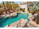 Serene backyard pool with rock waterfall, lush landscaping, and a charming gazebo area at 4200 Topsider St, Las Vegas, NV 89129