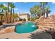 Backyard pool featuring rock waterfall, mature palms, and inviting lounge area at 4200 Topsider St, Las Vegas, NV 89129