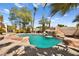 Stunning pool with rock waterfall feature surrounded by palm trees and meticulous landscaping at 4200 Topsider St, Las Vegas, NV 89129