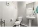 Small powder room with a pedestal sink, modern fixtures, and a wall-mounted mirror at 4220 Porticella Ave, North Las Vegas, NV 89084