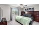 Comfortable bedroom with natural light, dark wood furniture, and three framed pictures on the headboard at 4220 Porticella Ave, North Las Vegas, NV 89084