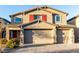 Charming two-story home featuring a three-car garage, brick driveway, and lovely red shutters at 4220 Porticella Ave, North Las Vegas, NV 89084