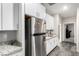 Well-lit kitchen features stainless steel refrigerator, granite counters and white cabinets at 4220 Porticella Ave, North Las Vegas, NV 89084