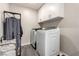 Well-lit laundry room with a modern washer and dryer and cabinets for storing laundry essentials at 4220 Porticella Ave, North Las Vegas, NV 89084