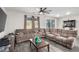 Comfortable living room with a large sectional sofa, ceiling fan, and sliding glass door leading to the backyard at 4220 Porticella Ave, North Las Vegas, NV 89084