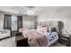 Bright main bedroom featuring a tufted headboard, decorative pillows, and a chandelier at 4220 Porticella Ave, North Las Vegas, NV 89084