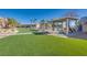 Landscaped community space featuring picnic tables, trellises, green turf, and nearby residences under a clear blue sky at 4626 Lime Straight Dr, Las Vegas, NV 89115