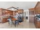 Bright kitchen with wooden cabinets, brick backsplash, and stainless appliances adjacent to tile floor dining area at 4716 Mountain Valley Rd, Las Vegas, NV 89121